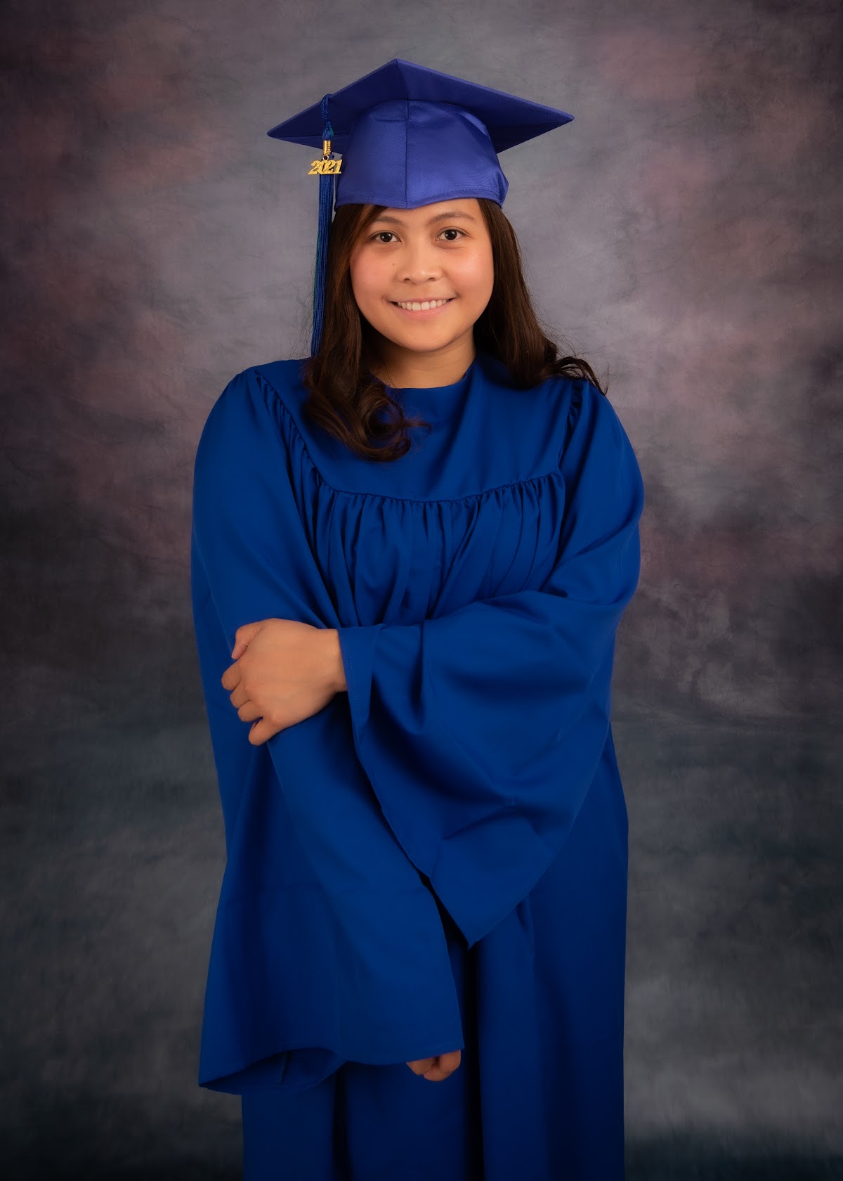Graduate portrait standing in a blue gown