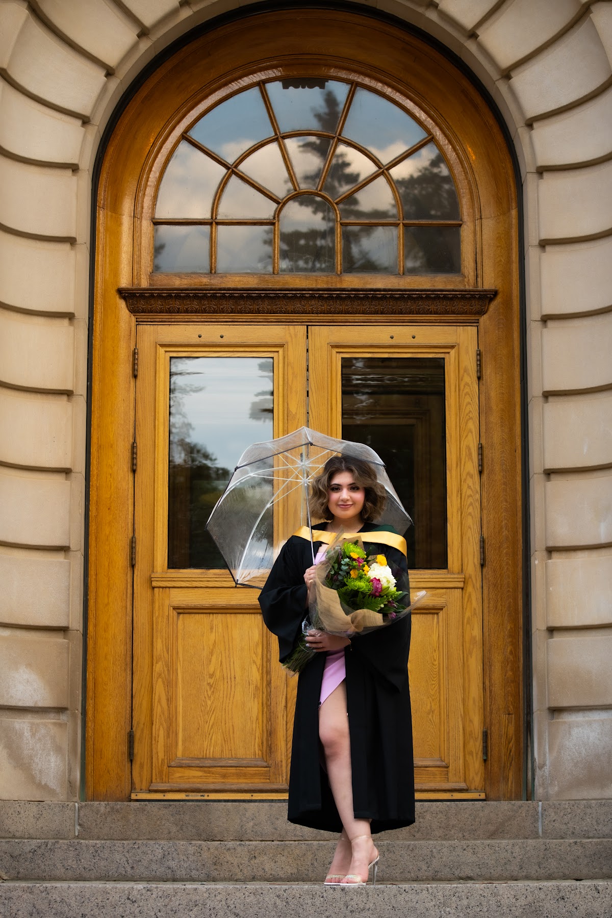 Full-length graduate portrait in an architectural setting